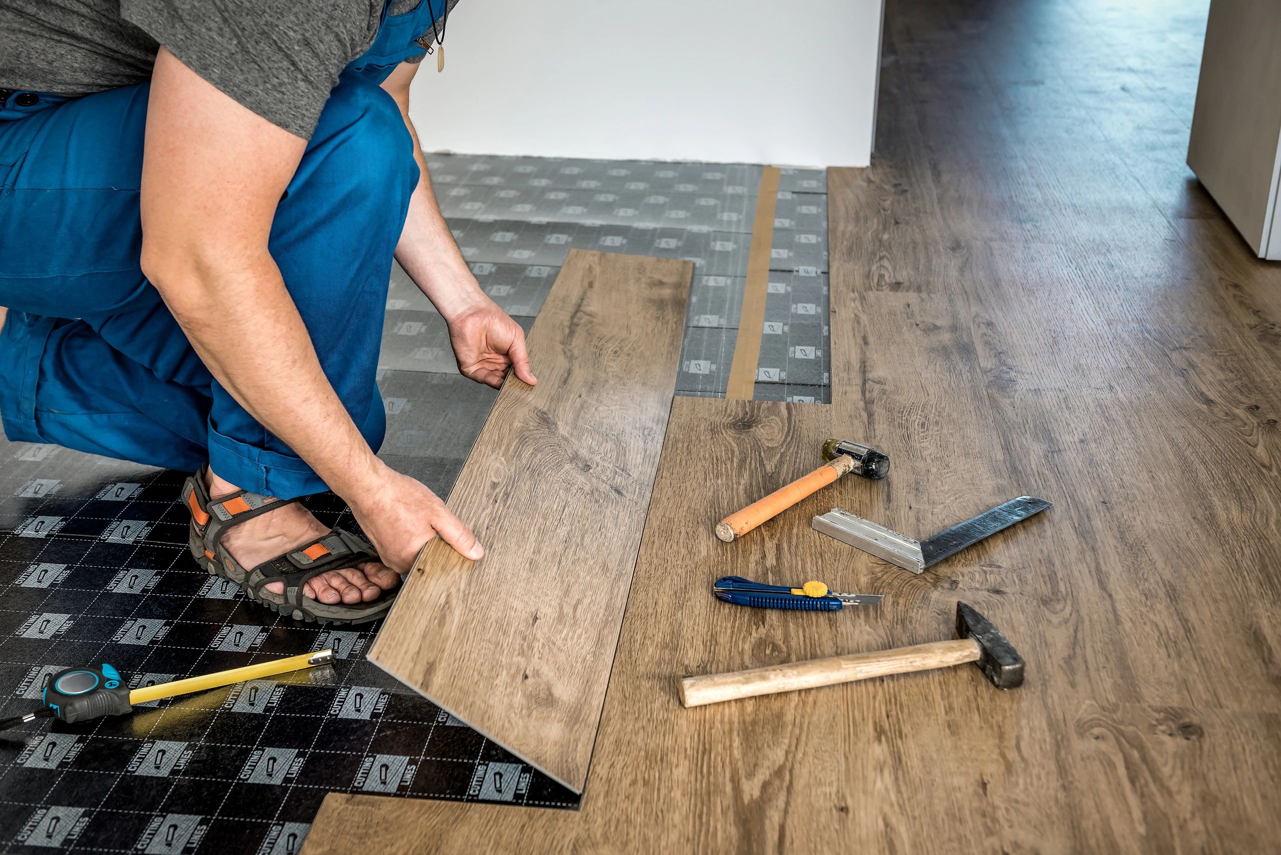 Worker installing flooring during a home renovation