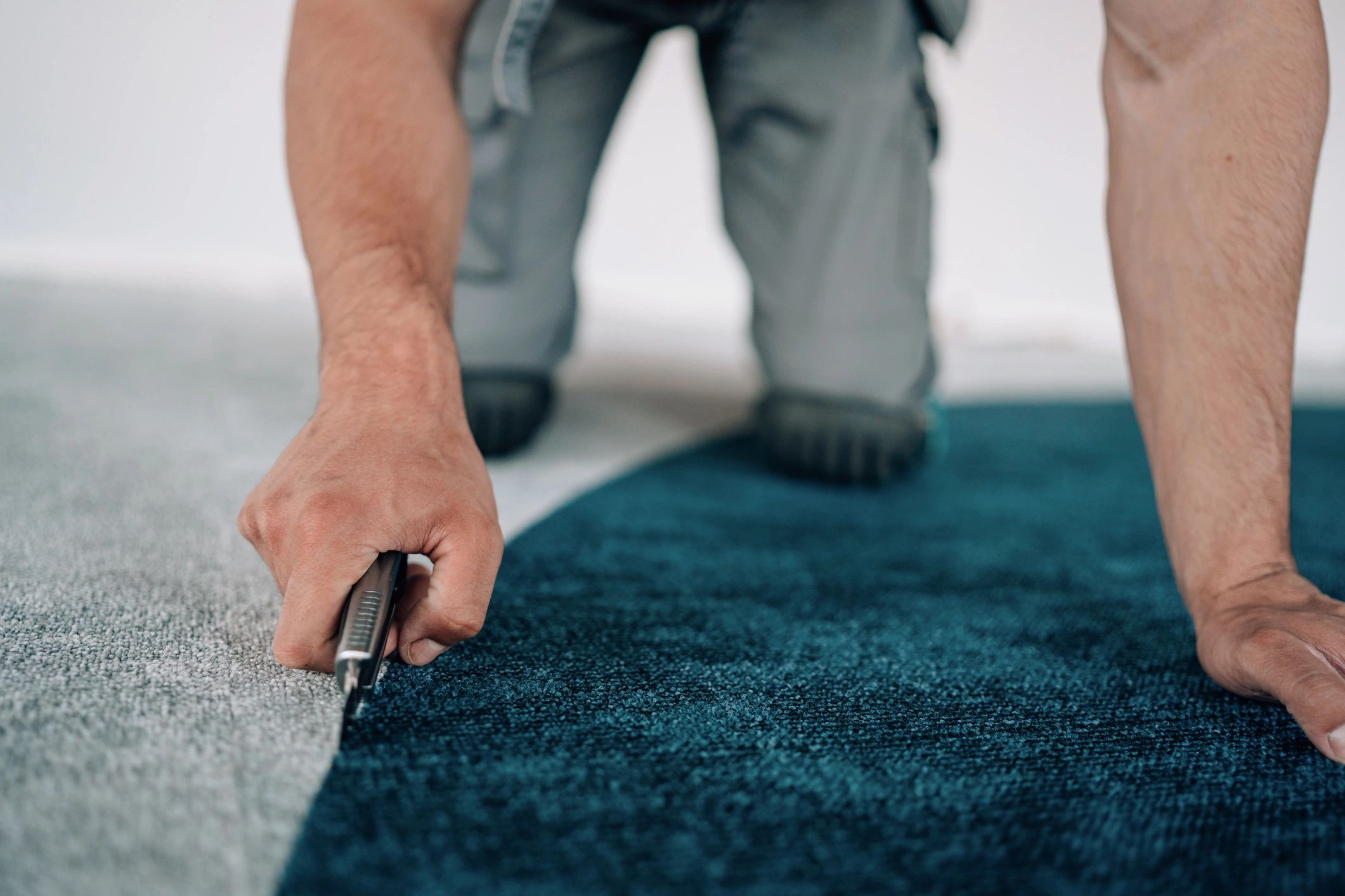 Installer fitting carpet in an interior space