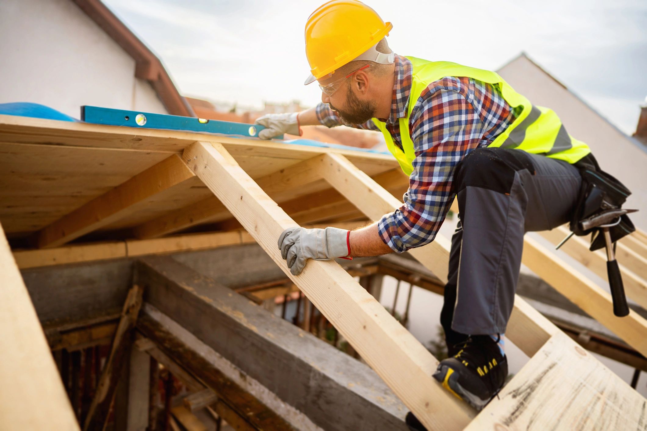 Roofer working on roof framing at a construction site